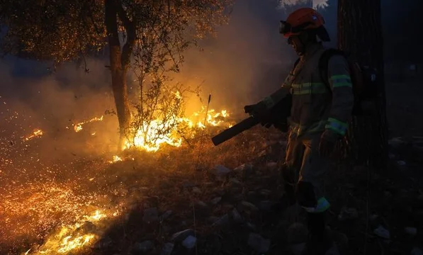 Un bombero irsraeli intenta apagar el fuego tras el ataque de Hezbollah